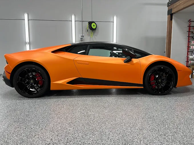 Bright orange Lamborghini supercar with black wheels and red calipers parked inside a well-lit install bay, showcasing a high-end wrap or protection service | Rodeo Werkz Auto Restyling | Dallas, TX